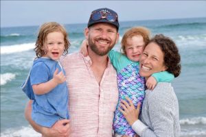 The LaHayne family posing for a photo and smiling on the beach